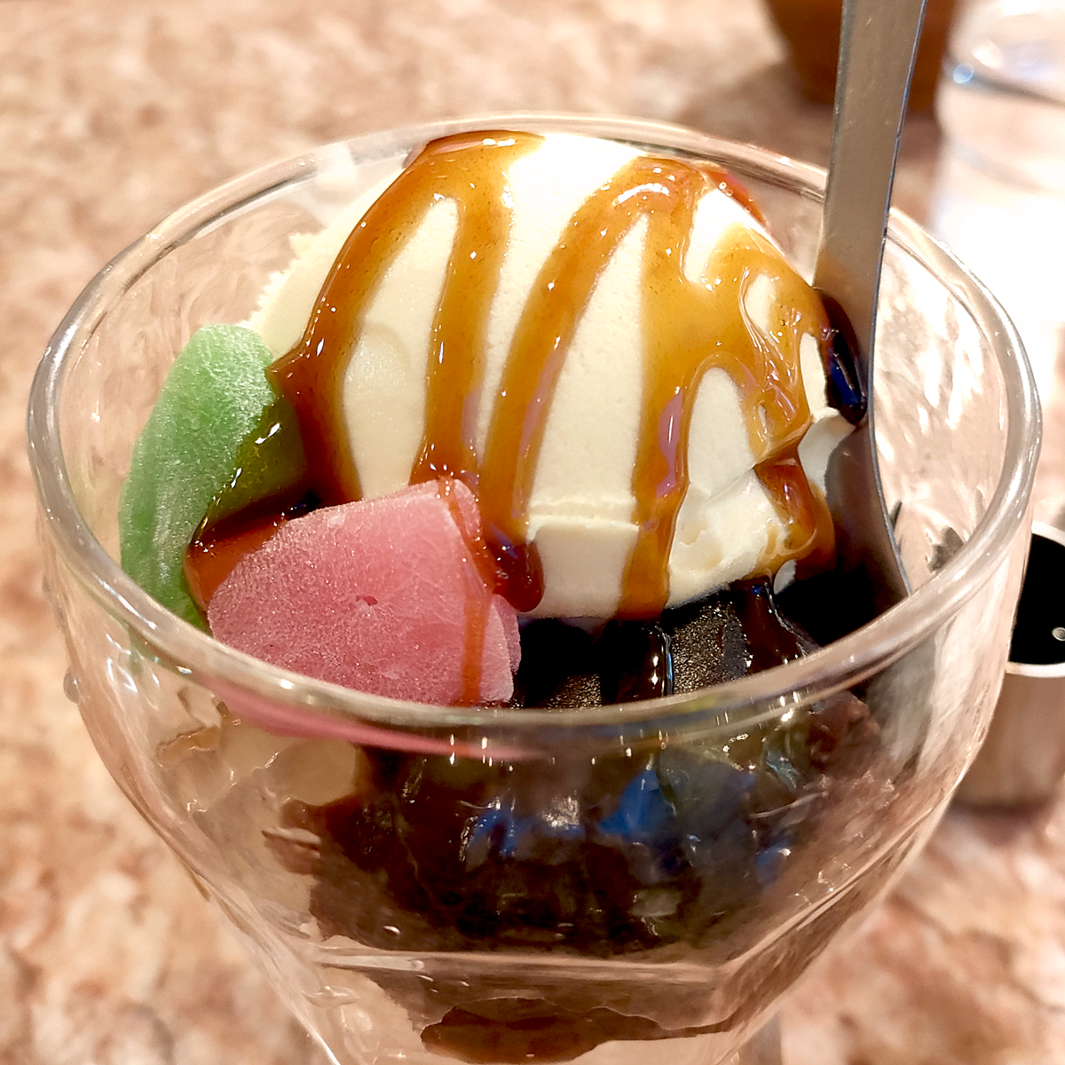 寒天と小豆と牛皮とアイスクリームが乗り黒蜜が掛かったあんみつの画像