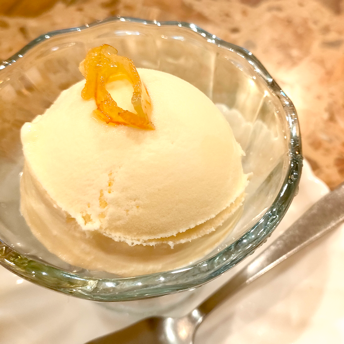 オレンジピールがトッピングされたバニラアイスクリームの画像